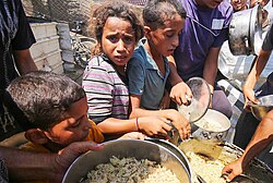 Crianças palestinas em busca de auxílio alimentar